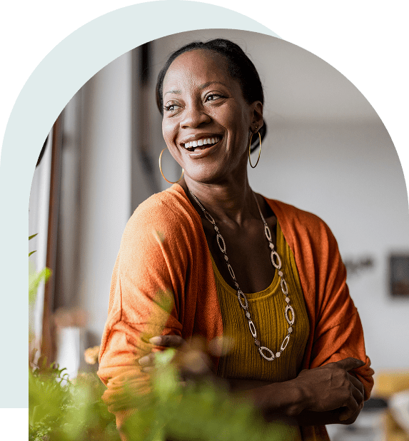 Smiling woman in orange cardigan indoors.
