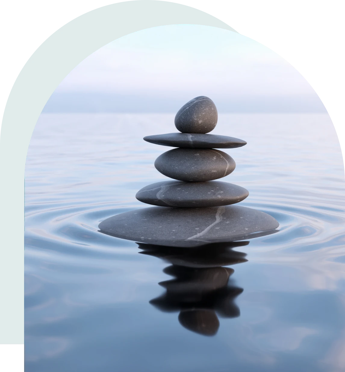 Stacked stones on calm water surface.