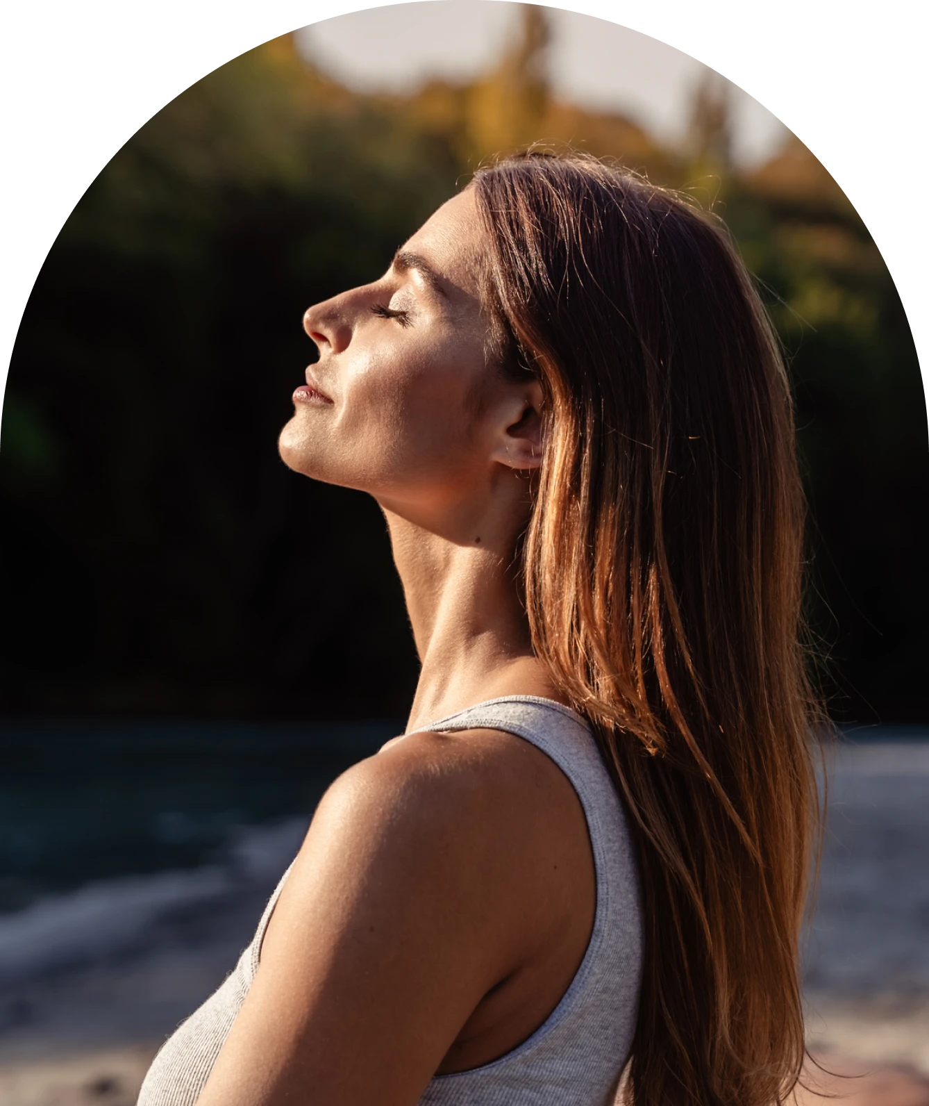 Woman enjoying sunlight by the water.